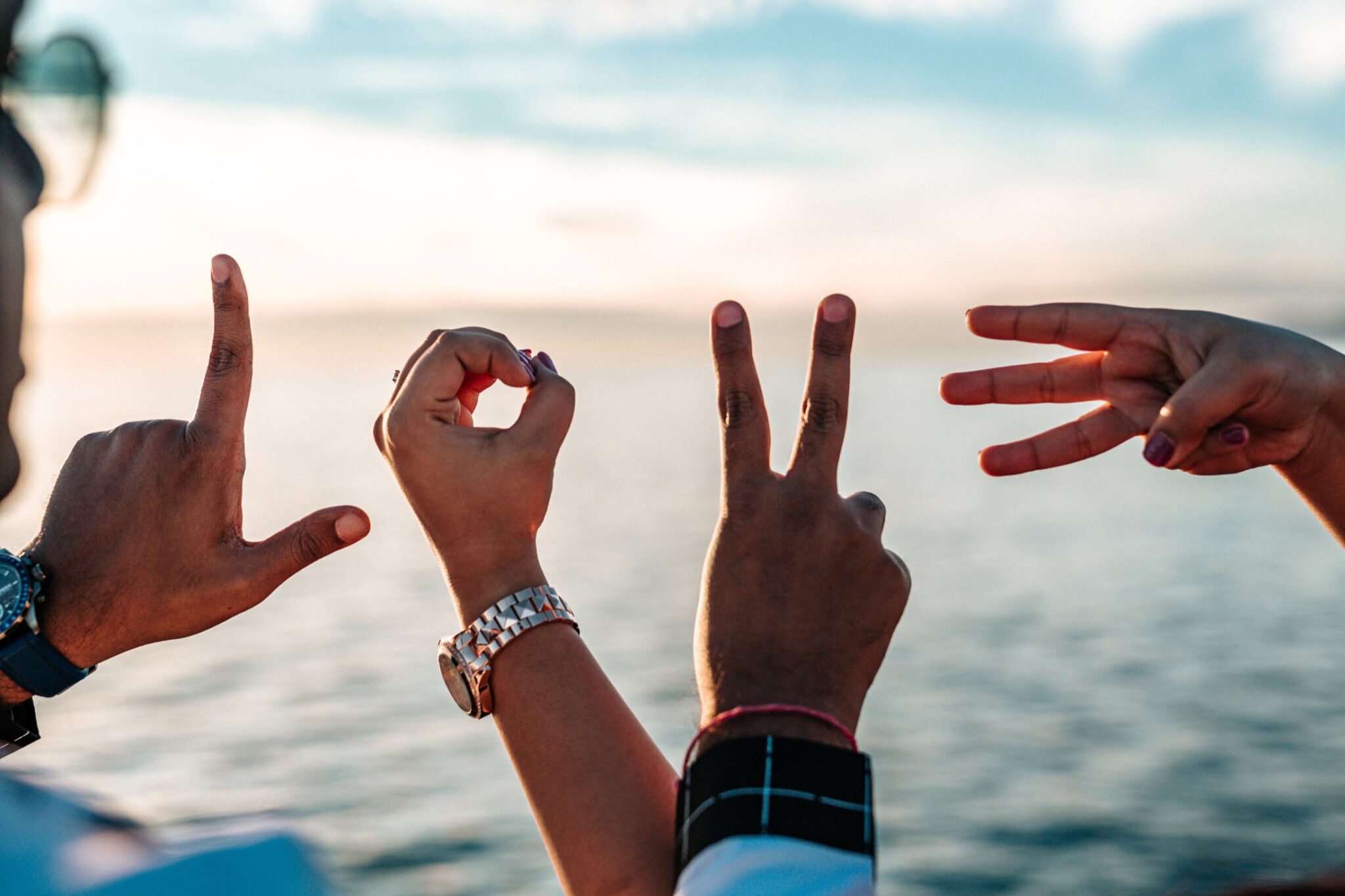 LOVE spelled with hands over the ocean