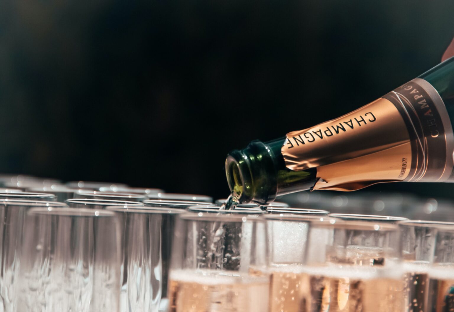 Champagne being poured into many bottles for a group