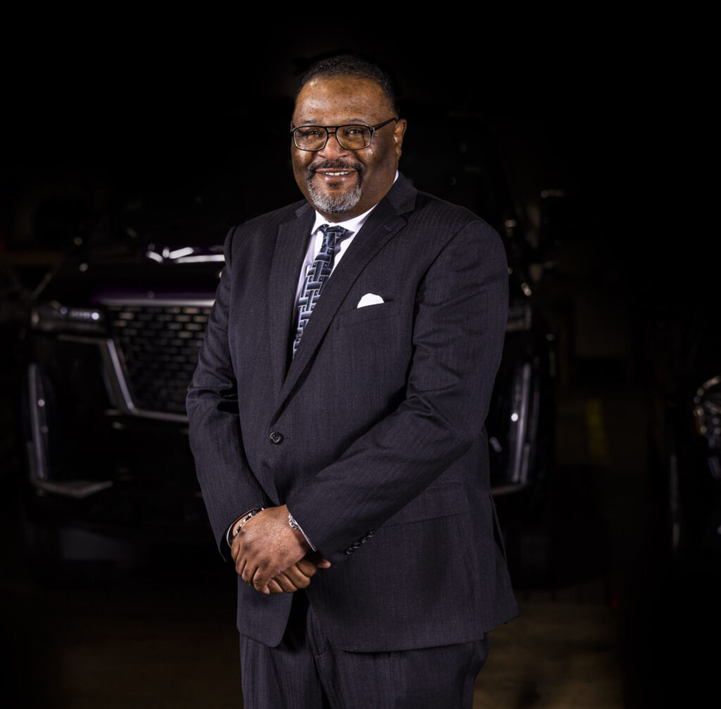 Kere Greene standing in front of a Cadillac