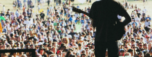 Country singer playing guitar at an outdoor concert.