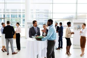 Business conference attendees at a networking session after riding on a charter bus from their hotel.