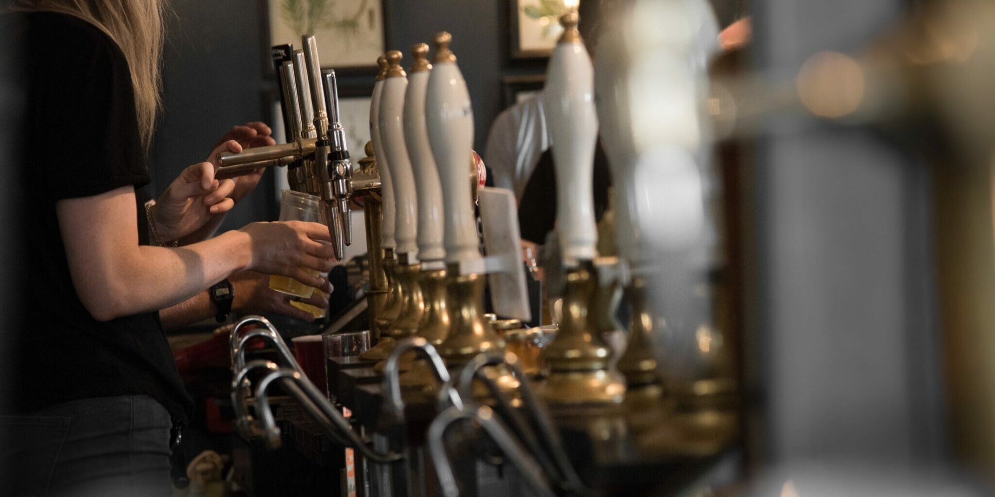 A row of beer taps at a bar
