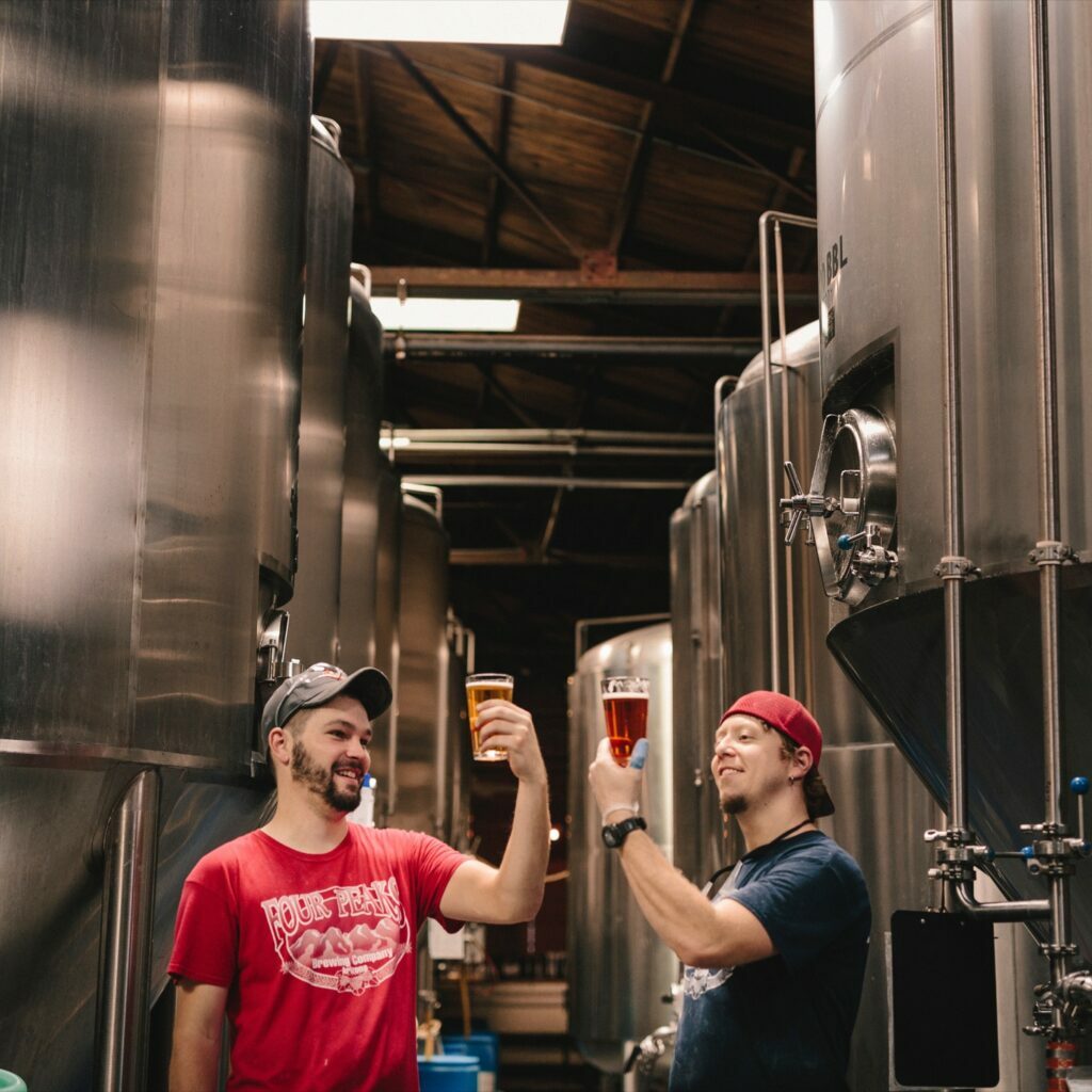 Two brewery employees inspect the beer