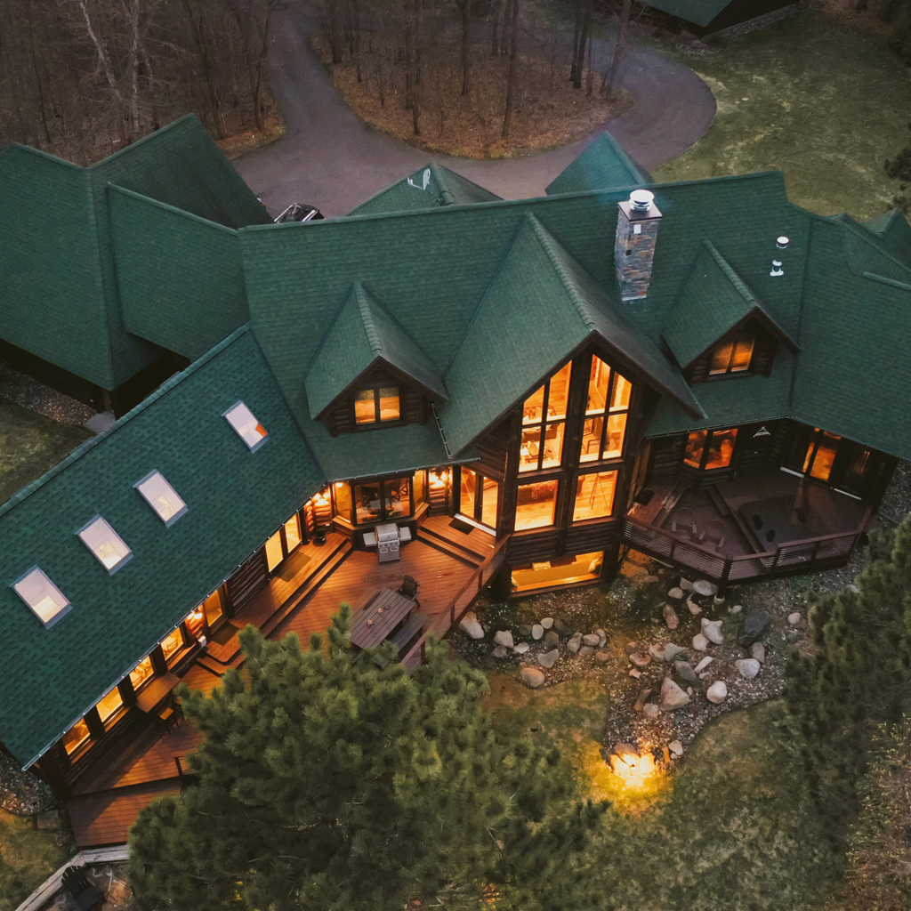 Overhead view of a large cabin in the woods.