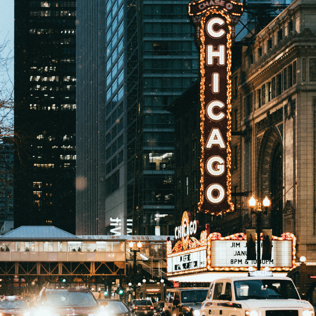 Traffic flows through the busy streets in front of the Chicago Theater