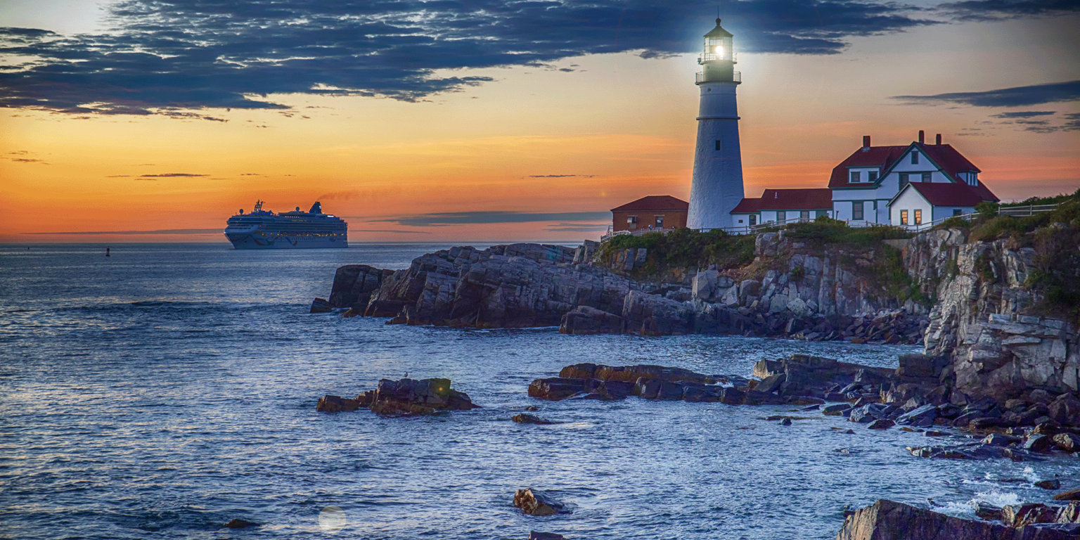 Photo of the Maine coastline at sunset with a Lighthouse and ship in the background.