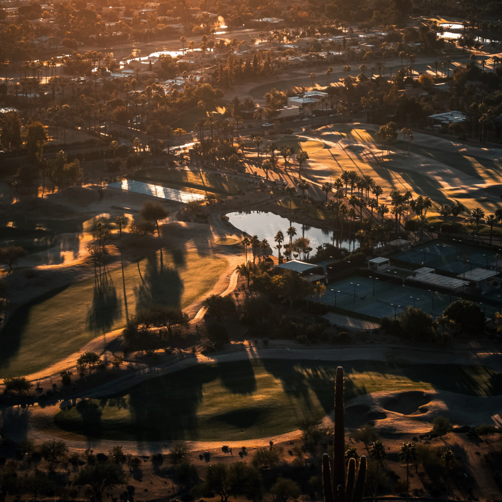 Phoenix landscape at sunset with golf course and tennis courts in the forground