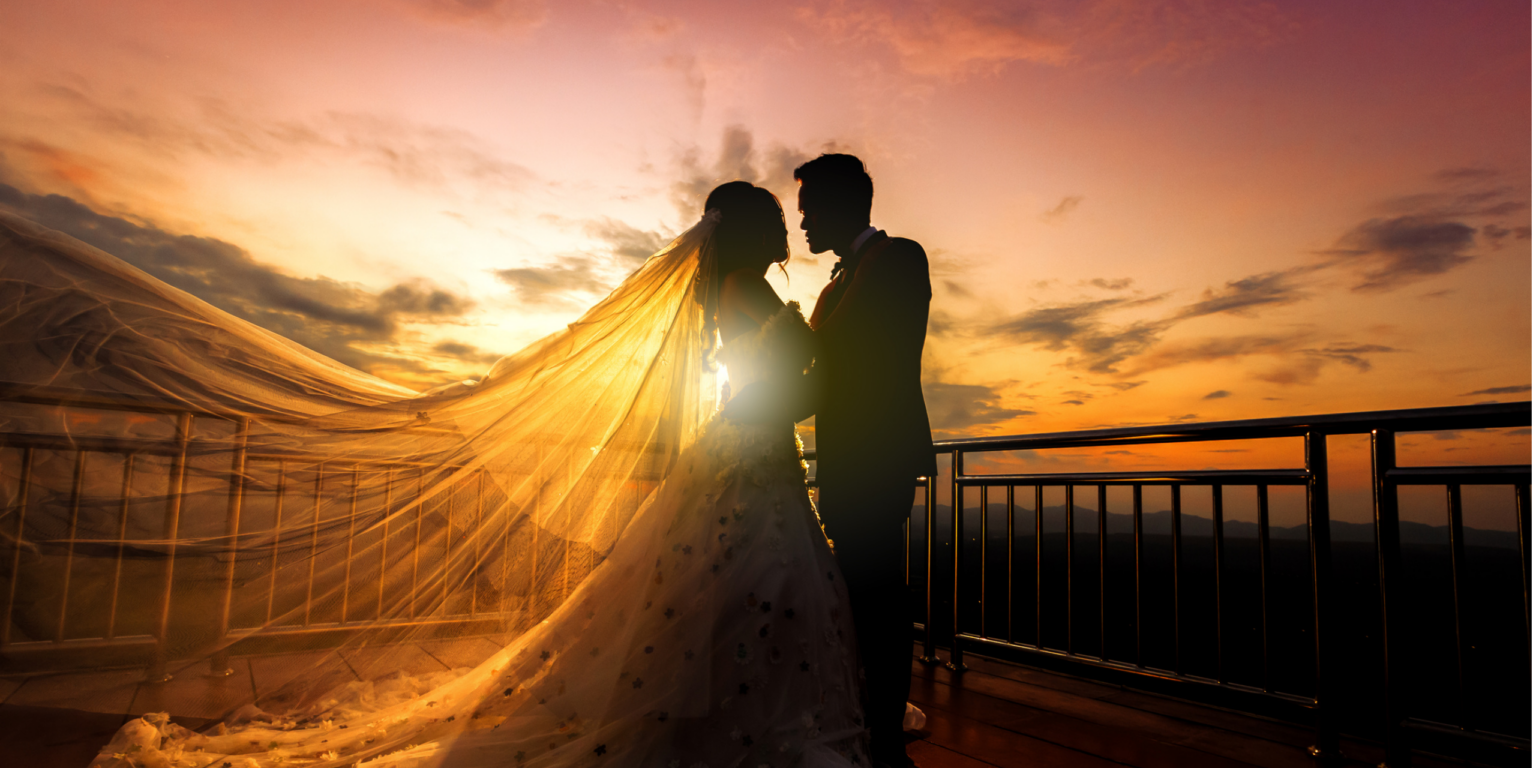 Wedding couple sharing a private moment outdoors at sunset